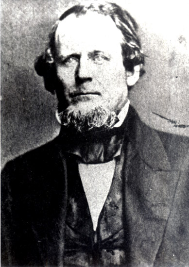 White man with beard in suit and white shirt