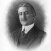 White man with mustache in three-piece suit above signature reading "R. E. Lee Wilson"