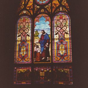 Stained glass window featuring robed figure of Jesus