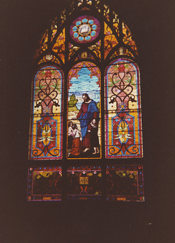 Stained glass window featuring robed figure of Jesus