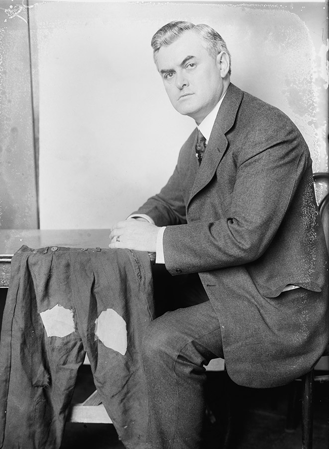 White man in suit sitting in chair