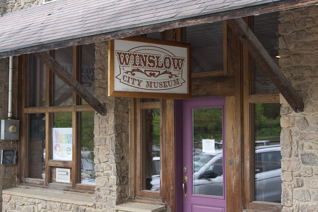 Brick and stone building with "Winslow City Museum" sign over a purple door