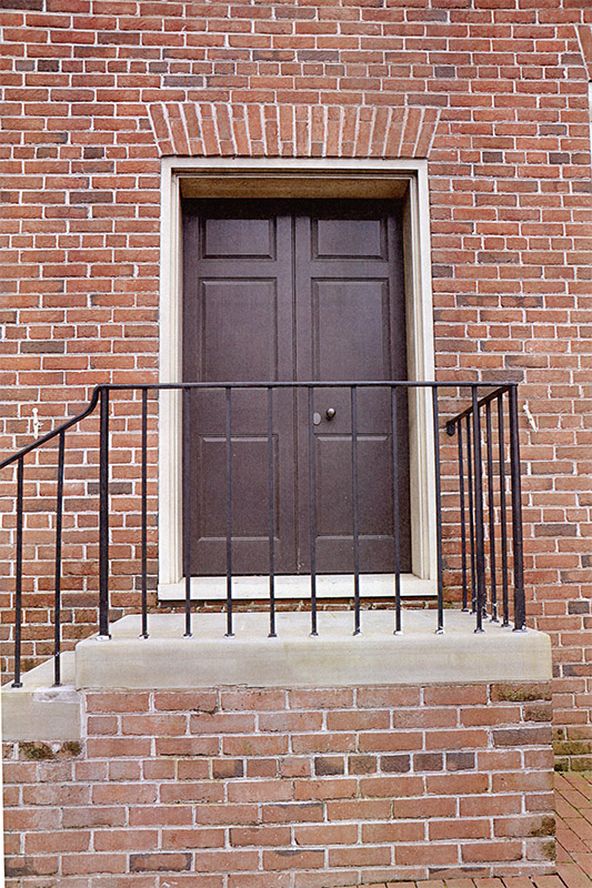 Close-up of front door of brick building with staircase