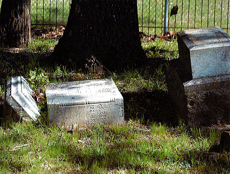 Broken "Gilbert" gravestone in cemetery