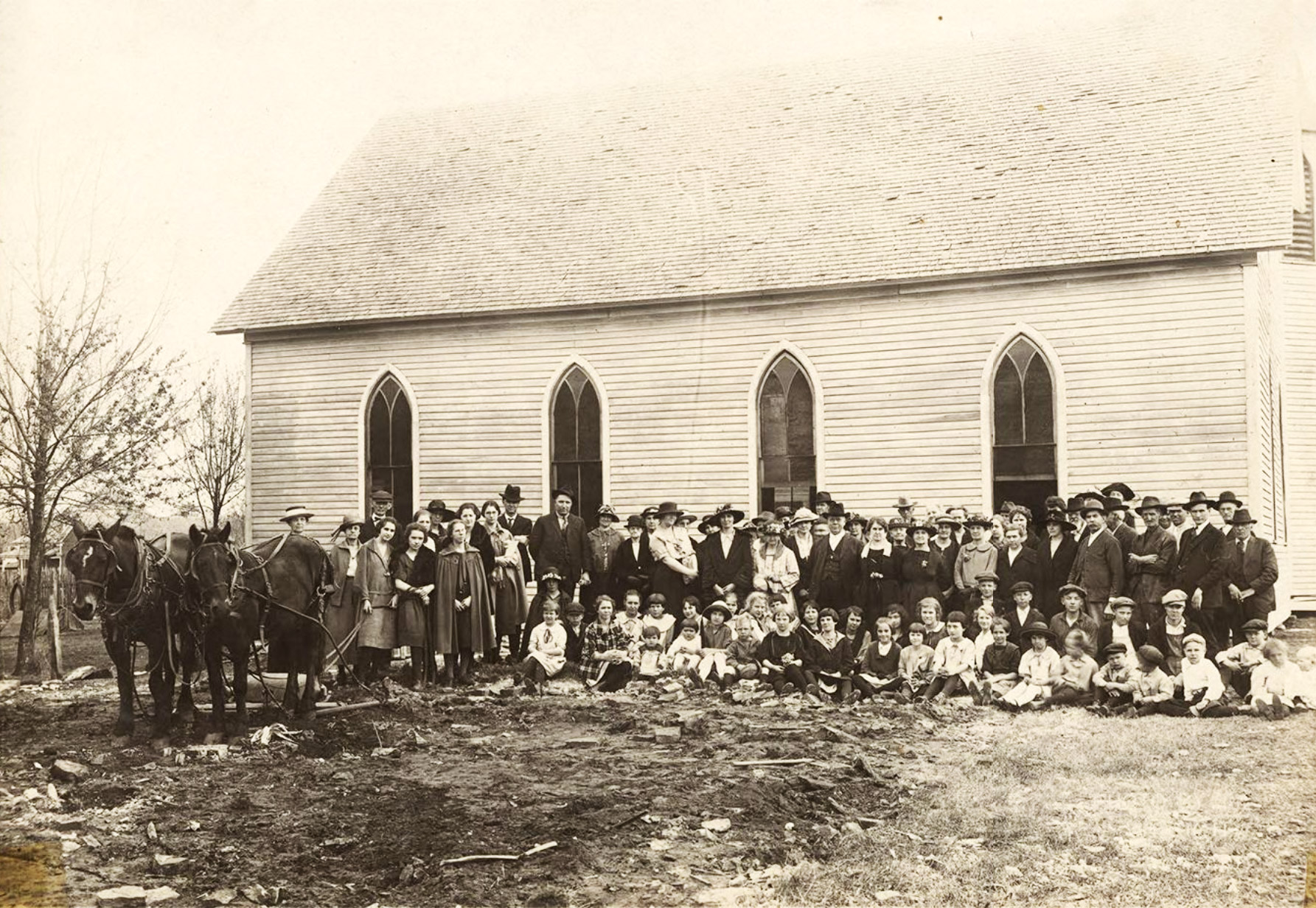 Large group of people standing before church building