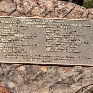 Large rock with memorial plaque on it listing victims names and hometowns for each