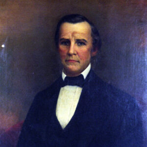 White man with dark hair in black suit, bow tie, and white shirt
