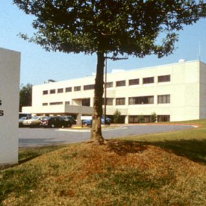 "Arkansas Children's Hospital" sign showing child's head silhouette and logo with entrance lawn driveway cars and multistory building