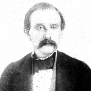 White man with mustache in jacket and shirt