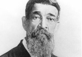 Old African-American man with a long beard in suit wearing a medal