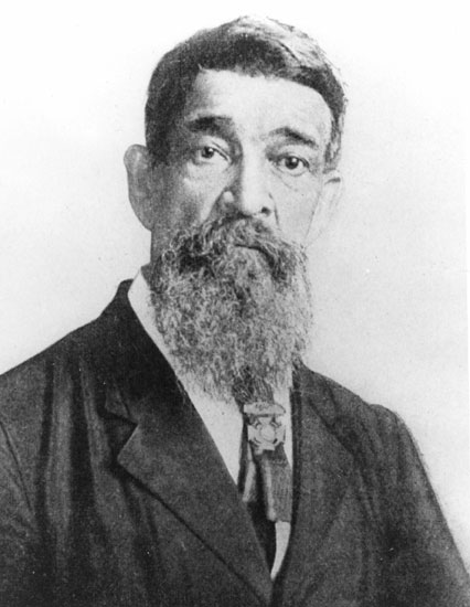 Old African-American man with a long beard in suit wearing a medal