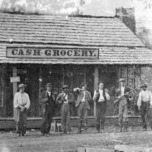 Group of white men with guns outside "Cash Grocery" store