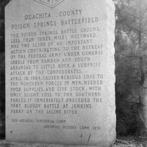 Stone monument "Ouachita County Poison Springs Battlefield" with trees in the background