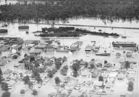 Aerial view of flooded town with trees in the distance