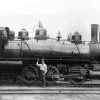 White engineer posing, standing with hand on locomotive