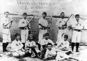 Baseball team photo with white men in "WR" jerseys holding bats, hand-signed "Walnut Ridge B.B Club. 1894."