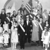 Group photo white people wearing various text sashes on stage, three flags including U.S.