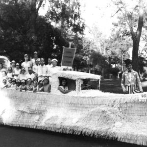 Parade float in boat design labeled "Prohibition" with fringe and riders, white men, women, children
