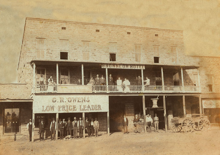 People posing in balcony and in front of hotel and store