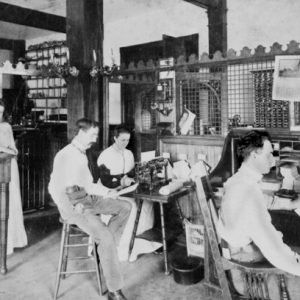 Interior office with workers two women and men and equipment desks lattice screen wall