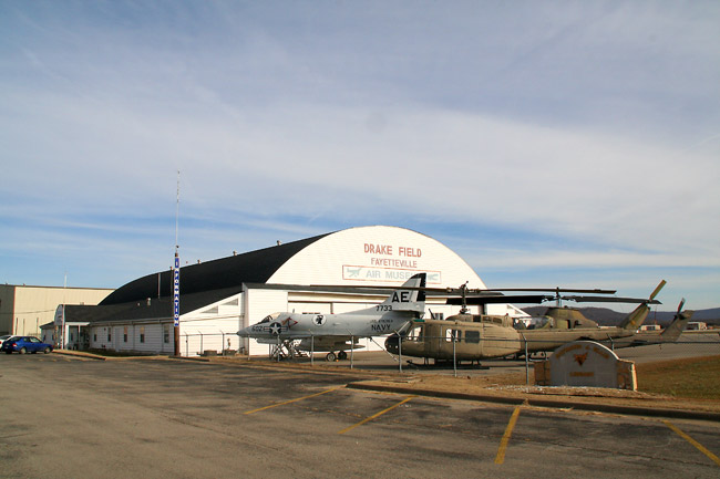 airplane hangar labeled "Drake Field Fayetteville" with military airplane and helicopter
