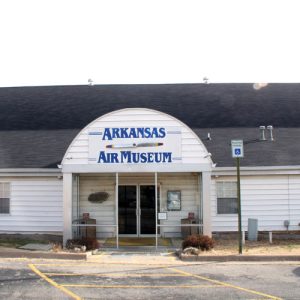 white wooden building with arched entryway "Arkansas Air Museum"