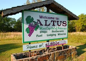 "Welcome to Altus" sign with brick base and roof