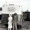African-American man in overalls and white woman in white western wear with hat with Coleman dairy truck