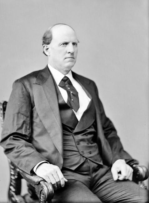 Portrait white man balding stern expression three piece suit tie seated on carved wooden chair