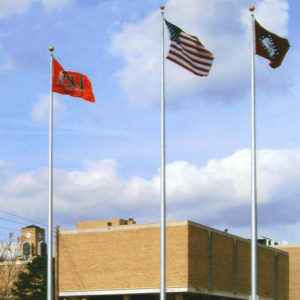 school flag, U.S. flag, and state flag outside of university