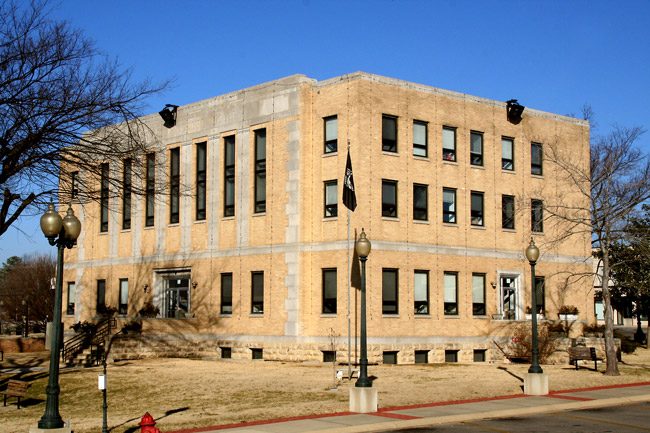 three story concrete building with lamp posts in front