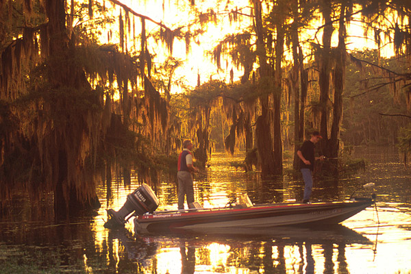 two white man in power boat fishing in bayou