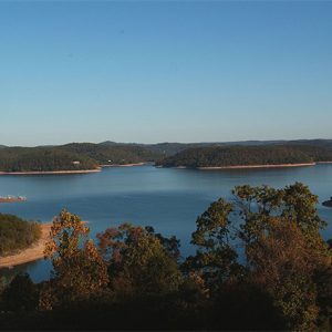 Lake with tree covered shores and hills in the distance