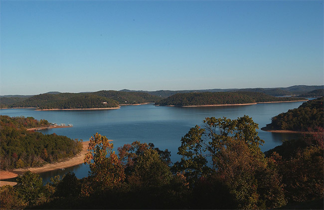 Lake with tree covered shores and hills in the distance