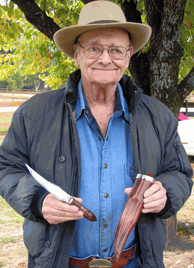 older white man holding knife and sheath