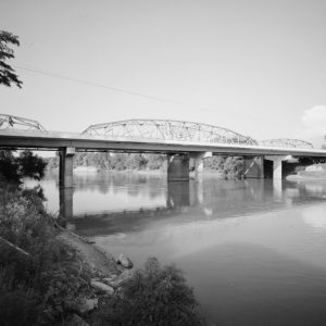 Highway bridge and river with river bank in foreground