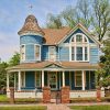 blue Victorian style two-story house with iron fence