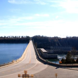 bridge over dam with lake on left and dam on right