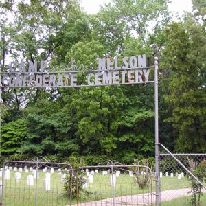 iron gate and sign "Camp Nelson Confederate Cemetery" in front of field with gravestones