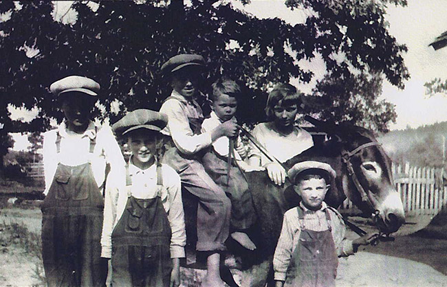 White children posing with donkey