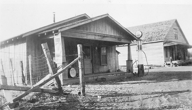 Gas station with single pump and storefront on dirt road