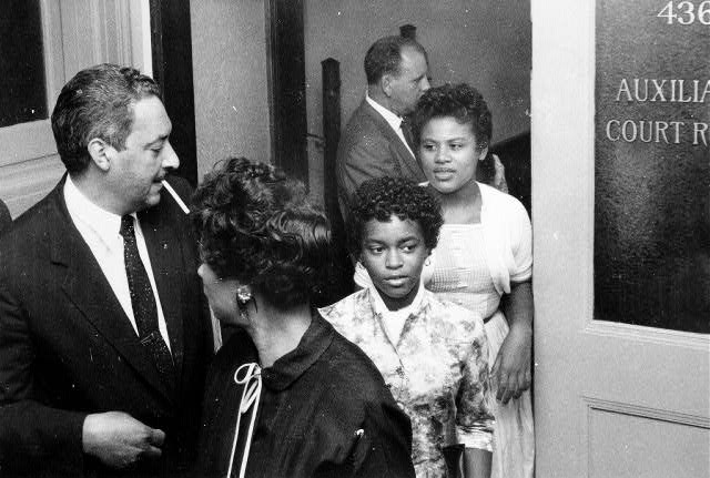 African American man and three African American women  leaving room labeled "auxiliary court room"