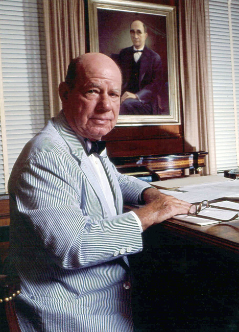 Portrait of white man in seersucker suit, bow tie, seated at writing desk