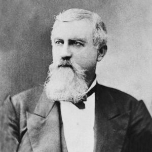 White man with long beard in suit and bow tie
