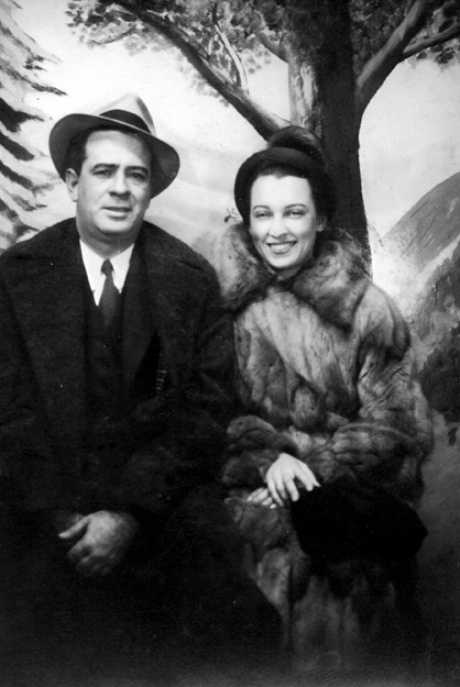 white man and woman in formal winter clothing posing by painted  nature backdrop