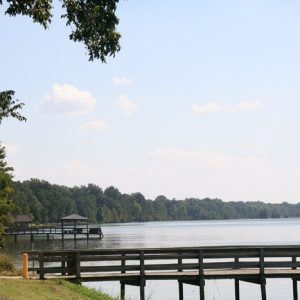 Covered fishing docks on lake with tree covered shores in the background