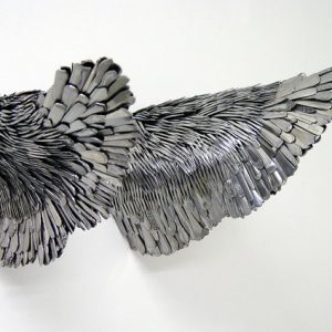 sculpture pair wings made of silverware mounted on blank wall