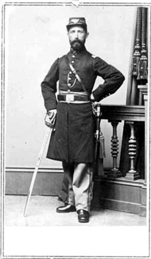 Bearded white man in military uniform with sword posing next to banister