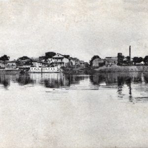 City viewed from river with barge and water tower