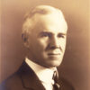 older white man in suit with striped tie